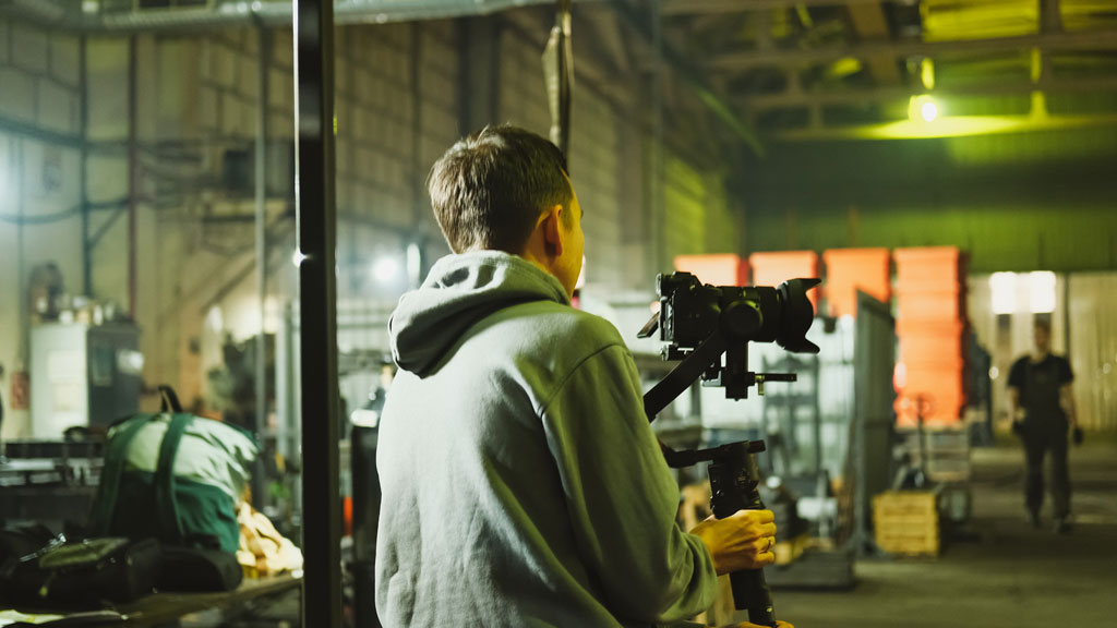 Technicien positionnant un panneau LED sur tournage corporate avec perche micro visible