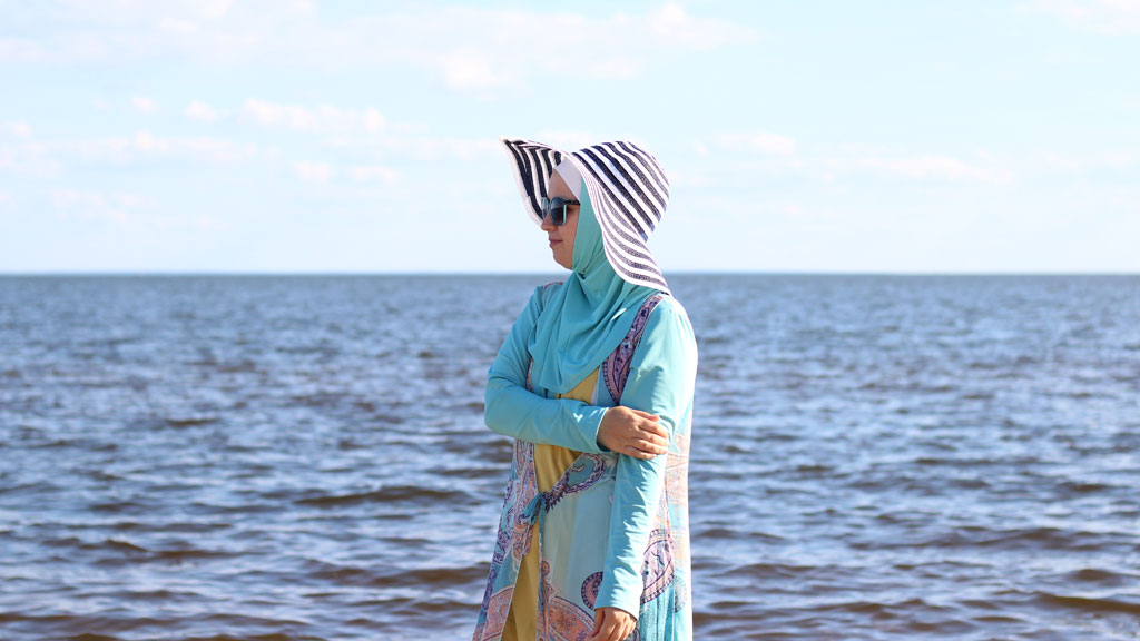 Femme sortant de l'eau avec burkini ample tissu fluide non collant